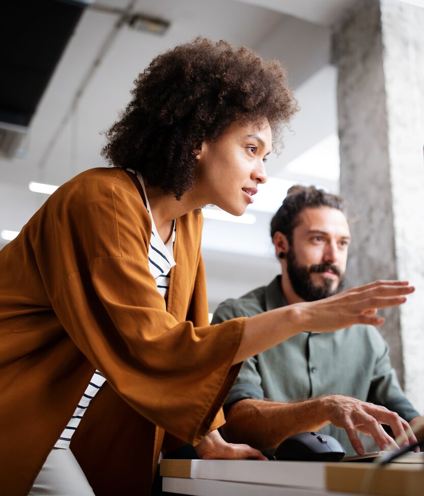 Two people in an office speaking about their tasks. 