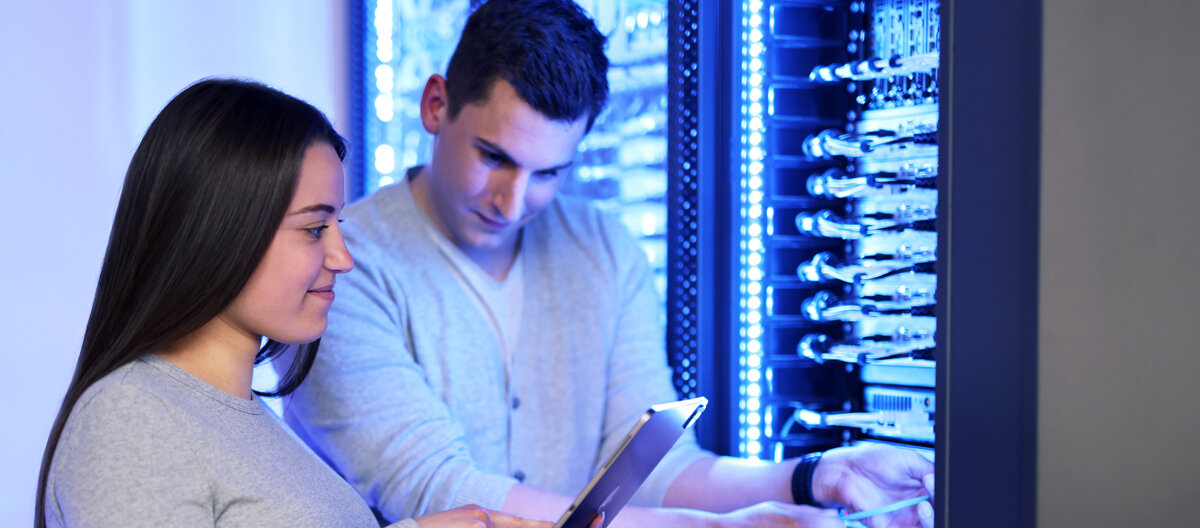 Two employees work at the server rack