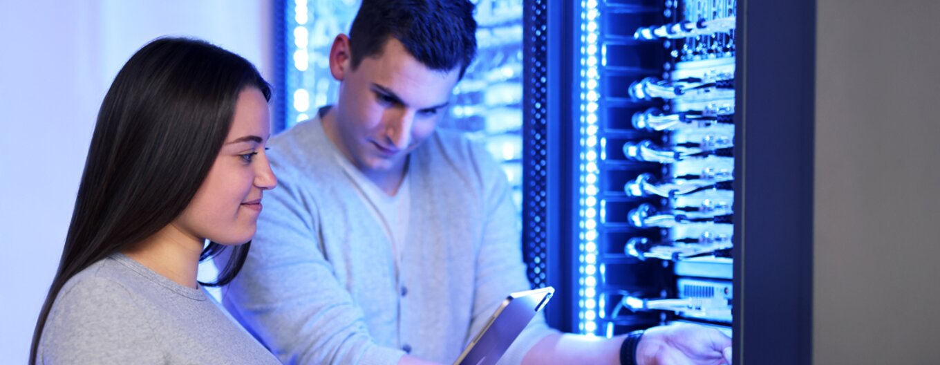 Two employees work at the server rack